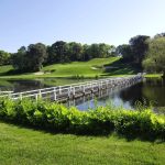 Panoramic view of a lush green golf course at Blue Rock Golf Course. Smooth