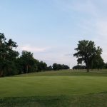 Panoramic view of a lush green golf course at Brent Bruehl Memorial Golf Course. Smooth
