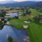 Panoramic view of a lush green golf course at Bronze Buffalo Ranch at Teton Springs. Smooth