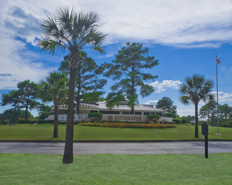 Panoramic view of a lush green golf course at Burning Ridge Golf Club. Smooth