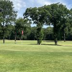 Panoramic view of a lush green golf course at Burns Park Golf Course. Smooth