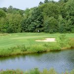 Panoramic view of a lush green golf course at Button Hole. Smooth