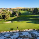 Panoramic view of a lush green golf course at Canyon Lakes Golf Course. Smooth