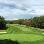 Panoramic view of a lush green golf course at Cape Cod Country Club. Smooth