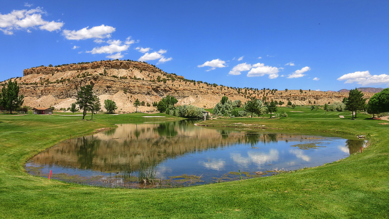 Panoramic view of a lush green golf course at Carbon Country Club Golf Course. Smooth