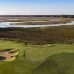 Panoramic view of a lush green golf course at Carolina National Golf Club. Smooth