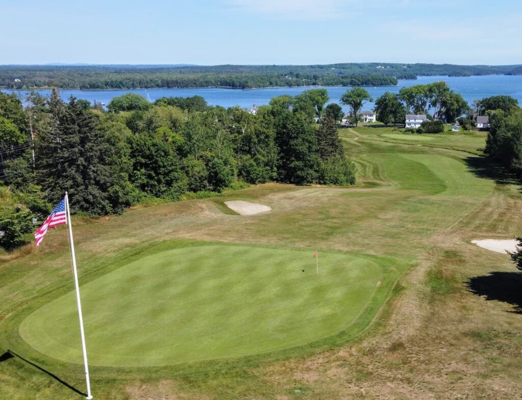 Panoramic view of a lush green golf course at Castine Golf Club. Smooth