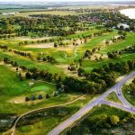 Panoramic view of a lush green golf course at Cattail Crossing Golf Course. Smooth