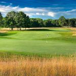 Panoramic view of a lush green golf course at Cedar Chase Golf Club. Smooth