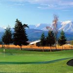 Panoramic view of a lush green golf course at Cedars at Dungeness Golf Course. Smooth