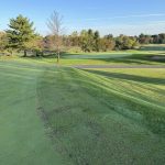 Panoramic view of a lush green golf course at Charlie Vettiner Golf Course. Smooth