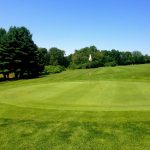 Panoramic view of a lush green golf course at Cherry Hill Golf Course. Smooth