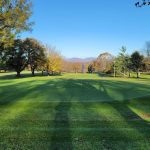 Panoramic view of a lush green golf course at Colonial Hills Golf Club. Smooth