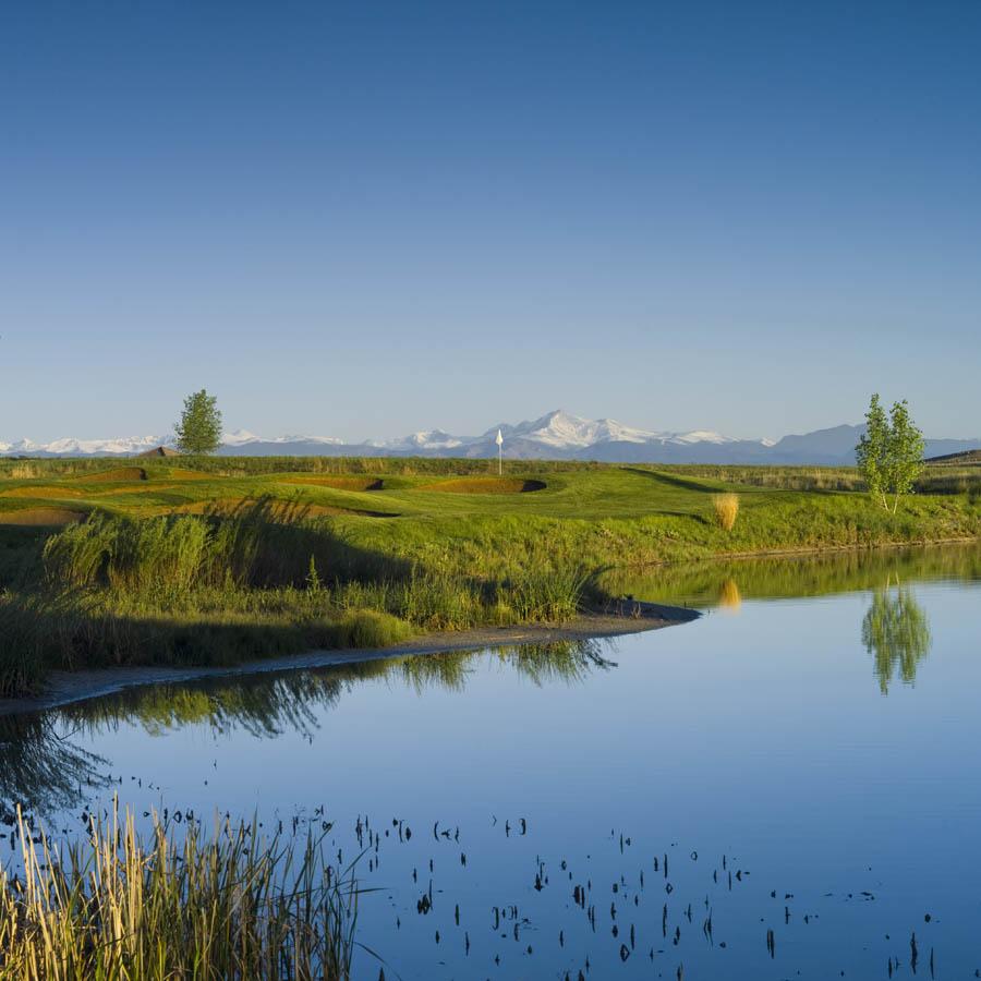 Panoramic view of a lush green golf course at Colorado National Golf Club. Smooth