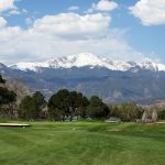 Panoramic view of a lush green golf course at Colorado Springs Country Club. Smooth