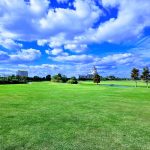 Panoramic view of a lush green golf course at Contraband Bayou Golf Club. Smooth