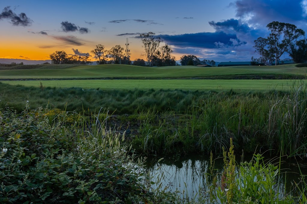 Panoramic view of a lush green golf course at Corica Park Golf Course. Smooth