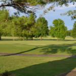Panoramic view of a lush green golf course at Cottonwood Golf Club. Smooth