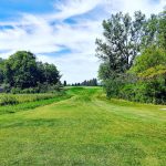 Panoramic view of a lush green golf course at Country Club Estates Golf Course. Smooth