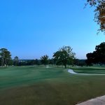 Panoramic view of a lush green golf course at Country Club of Mobile. Smooth
