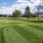 Panoramic view of a lush green golf course at Cove View Golf Course. Smooth