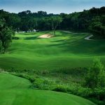 Panoramic view of a lush green golf course at Cowboys Golf Club. Smooth