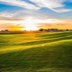 Panoramic view of a lush green golf course at Coyote Creek Golf Course. Smooth