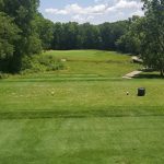 Panoramic view of a lush green golf course at Coyote Crossing Golf Club. Smooth