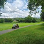 Panoramic view of a lush green golf course at Creekside Golf Course. Smooth