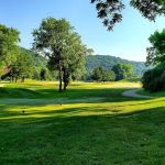 Panoramic view of a lush green golf course at Creekside Golf Course. Smooth