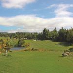 Panoramic view of a lush green golf course at Crestview Golf Club. Smooth