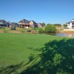 Panoramic view of a lush green golf course at Crimson Creek Golf Course. Smooth