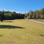 Panoramic view of a lush green golf course at Cross Creek Golf Course. Smooth