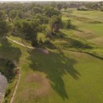 Panoramic view of a lush green golf course at Cross Creek Golf Links. Smooth