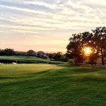 Panoramic view of a lush green golf course at Cypress Creek Golf Club. Smooth