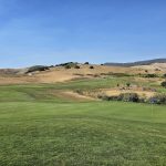 Panoramic view of a lush green golf course at Dairy Creek Golf Course. Smooth