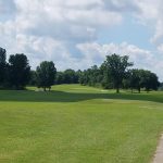 Panoramic view of a lush green golf course at Deer Lakes Golf Course. Smooth