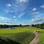 Panoramic view of a lush green golf course at Den at Fox Creek. Smooth