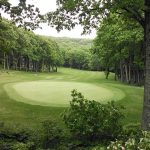 Panoramic view of a lush green golf course at Devils Knob Golf Course. Smooth
