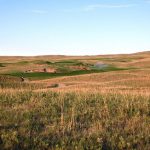 Panoramic view of a lush green golf course at Dismal River. Smooth