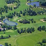 Panoramic view of a lush green golf course at Door Creek Golf Course. Smooth
