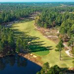 Panoramic view of a lush green golf course at Dormie Club. Smooth