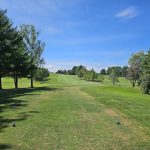 Panoramic view of a lush green golf course at Dutch Elm Golf Course. Smooth