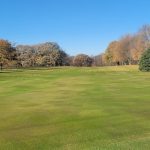 Panoramic view of a lush green golf course at Eagle Grove Golf Course. Smooth