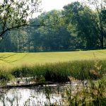 Panoramic view of a lush green golf course at Eagle Hills Golf Course. Smooth