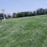 Panoramic view of a lush green golf course at Eagle Lake Golf. Smooth