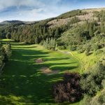 Panoramic view of a lush green golf course at EagleVail Golf Club. Smooth