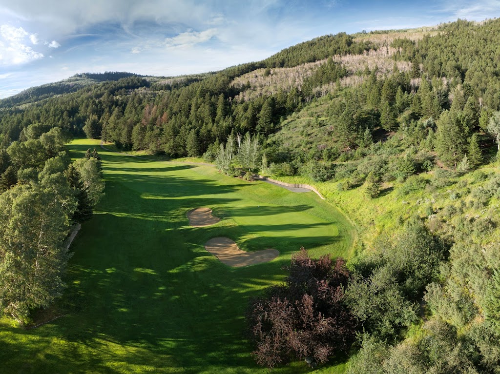 Panoramic view of a lush green golf course at EagleVail Golf Club. Smooth