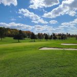 Panoramic view of a lush green golf course at Eagles Ridge Golf Course. Smooth