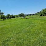 Panoramic view of a lush green golf course at Eaglewood Golf Course. Smooth